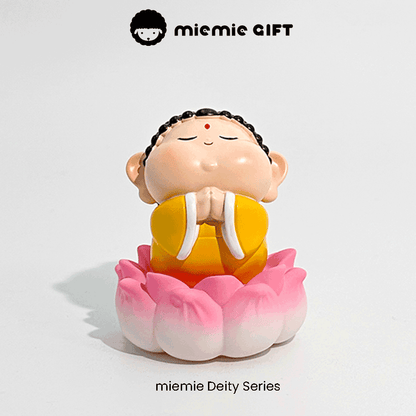 Meditative Buddha statue with colorful robes and a pink lotus flower base