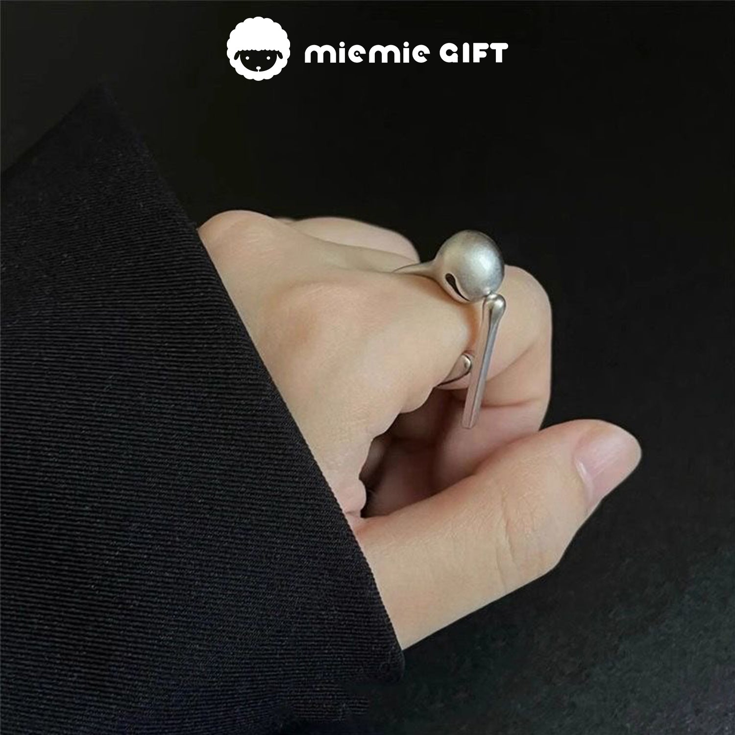 A hand wearing the Wooden Fish Silver Ring, featuring a sleek and minimalist design with a functional wooden fish mallet, ideal for stress relief and mindfulness, by MieMie Gift.