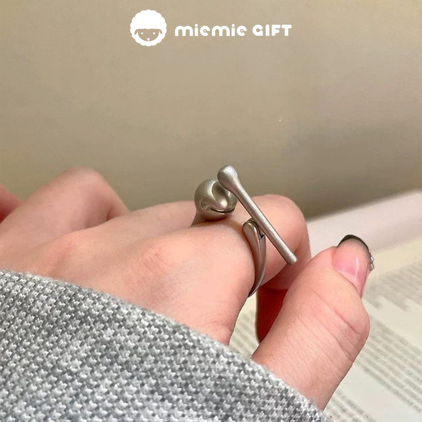 A close-up of the Wooden Fish Silver Ring worn on a hand, featuring a sleek design with a functional wooden fish mallet, ideal for stress relief and mindfulness, by MieMie Gift